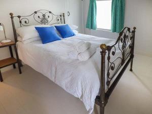 a bed with white sheets and blue pillows at Gatehouse in Painscastle