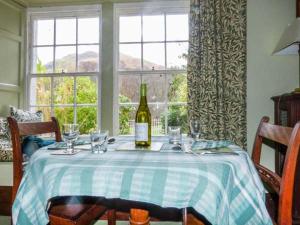 a bottle of wine sitting on a table with glasses at Townhead Cottage in Patterdale