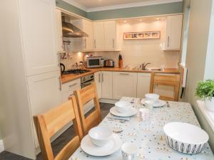 a kitchen with a table with dishes on it at Thompson Cottage in Troutbeck
