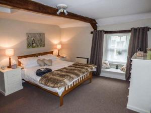 a bedroom with a large bed and a window at Castle Hill Cottage in Middleham