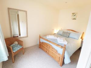 um quarto com uma cama, um espelho e uma cadeira em The Nook at Timbers em Great Longstone