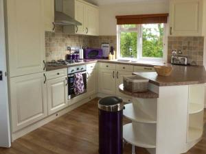 a kitchen with white cabinets and a counter top at Morgan Lodge in Puxton