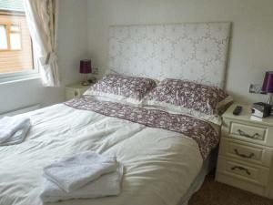 a bedroom with a white bed and a night stand at Morgan Lodge in Puxton