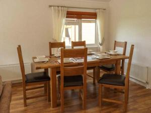 mesa de comedor con sillas y ventana en Morgan Lodge, en Puxton