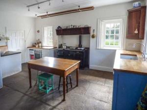 a kitchen with a wooden table and a counter top at Flanders Hall in West Burton