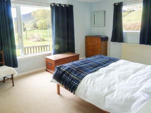 1 dormitorio con cama y ventana en Fronthill en Newtonmore