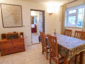 a dining room with a table and chairs and a room at Ty Woods Cottage in Rhoscolyn
