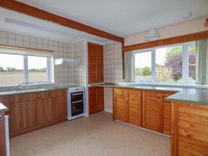a large kitchen with wooden cabinets and counters at Glenhaven in Rendham