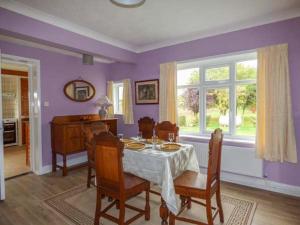 a dining room with purple walls and a table and chairs at Glenhaven in Rendham