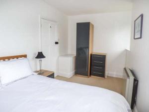 - une chambre avec un lit blanc et une commode dans l'établissement Groes Newydd Bach, à Llandecwyn