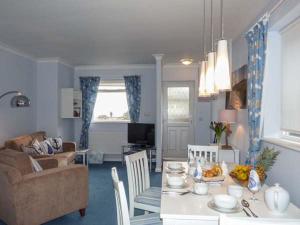 uma cozinha e sala de estar com uma mesa e um sofá em Herbrand House em Bexhill