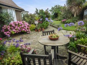 un patio con mesa, sillas y flores en Herbrand House, en Bexhill-on-Sea