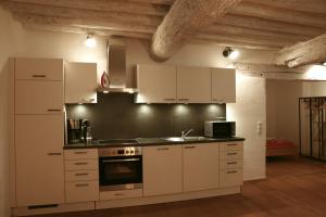 a kitchen with white cabinets and a stove top oven at Stilvolle Wohnung auf 50 m² mit Parkplatz und WiFi in Kraiburg am Inn