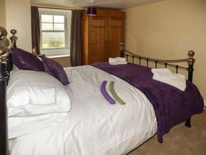 GunnersideにあるHillwaysのベッドルーム1室(紫と白のシーツが備わる大型ベッド1台付)