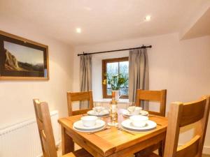 a dining room table and chairs with a wooden table at Cinderbarrow Cottage in Levens