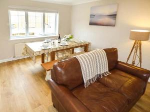 a living room with a leather couch and a table at Leap House in Wareham