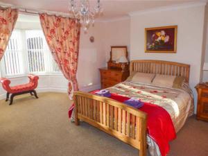 a bedroom with a large bed and a chair at Mayfield Manor in Whitby