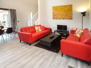 a living room with two red couches and a table at Everdene in Broadwey