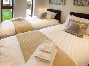 two white beds with pillows and towels on them at Everdene in Broadwey