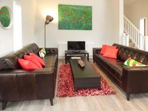 a living room with two leather couches and a table at Casterbridge in Broadwey