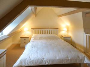 ウィットビーにあるOdd Sock Cottageのベッドルーム1室(白いベッド1台、ナイトスタンド2台付)