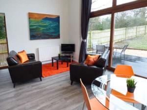 ein Wohnzimmer mit Sofas und einem Glastisch in der Unterkunft Shepherd Oak in Broadwey