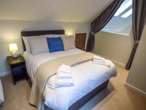 a bedroom with a large bed with blue pillows at Bramshurst in Broadwey