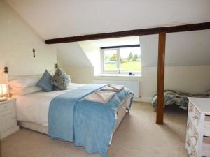 a bedroom with a large bed and a window at 2 Ysgubor Gerrig in Trefriw