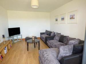 a living room with a couch and a table at Caeau Mawr in Henllan