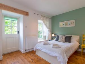 Un pat sau paturi într-o cameră la The Dale Cottage
