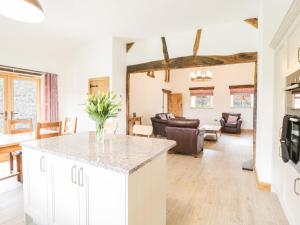 a kitchen and living room with a counter and a living room at Sgubor in Llangwm