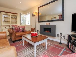 uma sala de estar com uma mesa e uma lareira em Little Willesleigh em Goodleigh