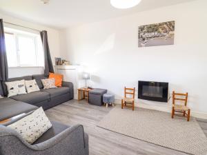 a living room with a couch and a tv at Sealyons in Fairbourne