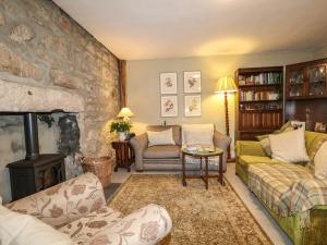 a living room with a fireplace and a stone wall at Coorie Doon in Nairn