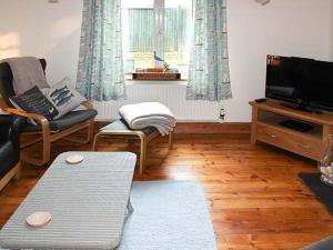 a living room with a couch and a tv at Driftwood Cottage in Heacham