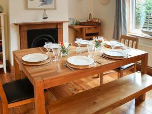 ヒーチャムにあるDriftwood Cottageのリビングルーム(木製テーブル、皿付)