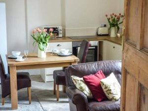 a living room with a table and a couch with pillows at Walcot Farm in North Lydbury