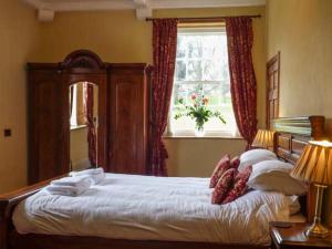 a bedroom with a large bed with white sheets and a window at Walcot Farm in North Lydbury