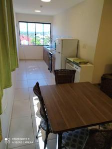 a kitchen with a wooden table and a table and chairs at Apart 2 habitaciones vista a Itaipú - 32 in Ciudad del Este
