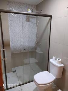 a bathroom with a toilet and a glass shower at Apart 2 habitaciones vista a Itaipú - 32 in Ciudad del Este