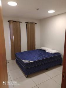 um quarto com uma cama azul num quarto em Apart 2 habitaciones vista a Itaipú - 32 em Ciudad del Este