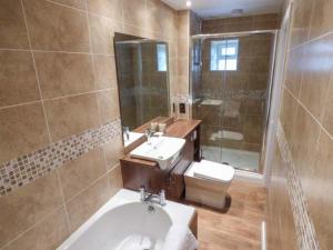 La salle de bains est pourvue d'un lavabo, de toilettes et d'un miroir. dans l'établissement Brig End, à Langthwaite