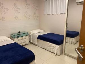 a room with two beds and a mirror at Carneiros Beach Resort - Flat 205-A in Praia dos Carneiros