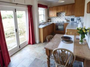 a kitchen with a wooden table with chairs and a dining room at The Conifers in Hutton Magna