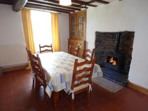 a dining room with a table and a fireplace at Ffynnon Gower in Llangower