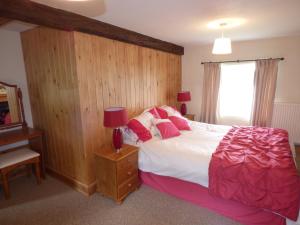 a bedroom with a large bed with a wooden wall at Ffynnon Gower in Llangower
