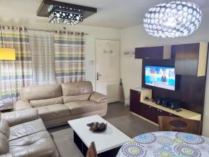 a living room with a couch and a tv at Amalfi Oasis Seaside Cebu in Cebu City