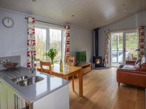 a kitchen and living room with a couch and a table at Shepherd Lodge in Cartmel
