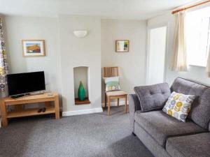a living room with a couch and a tv at 9 Swallow Court in Herne