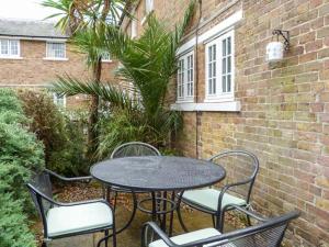 a patio table and chairs with a table and a building at 9 Swallow Court in Herne